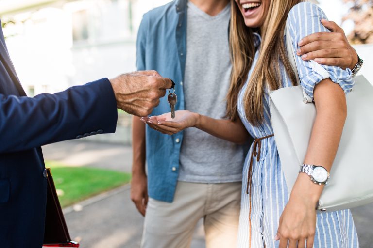 Real estate agent handing keys to happy home buyers, representing the shift toward focusing on qualified buyer clients